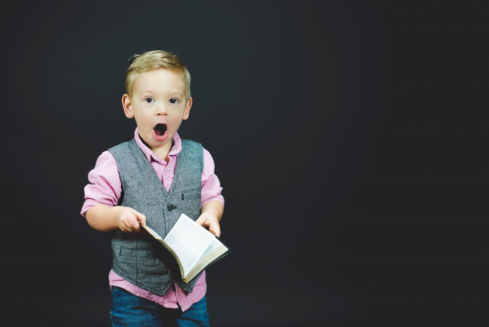 niño con cara de sorprendido leyendo un libro