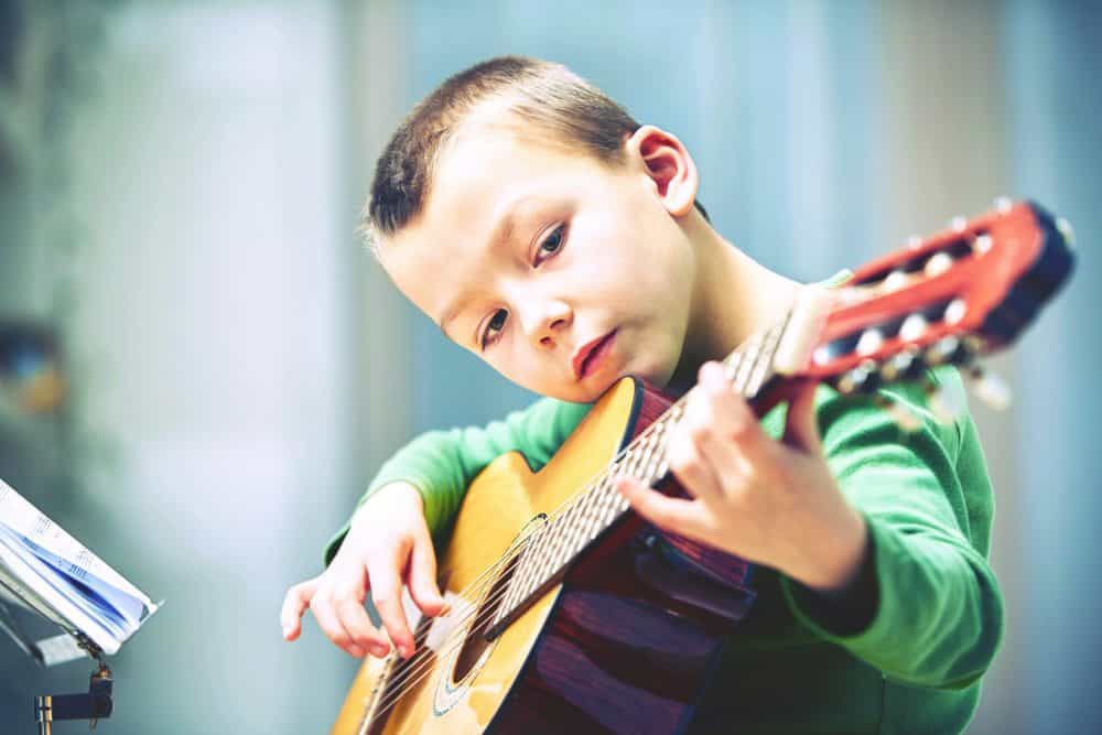 niño pequeño tocando la guitarra